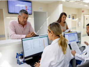 Patient:innnen an Empfangstheke in Arztpraxis