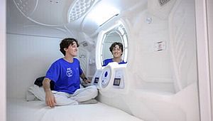 Bild zeigt jungen Mann in Simulation eines Innenraums einer  Weltraumrakete 