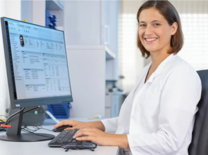 Ärztin vor PC mit Patientenakte auf Bildschirm