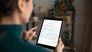 Frau hält Tablet, in dem Seite des Clusters Medizin.NRW zu sehen ist