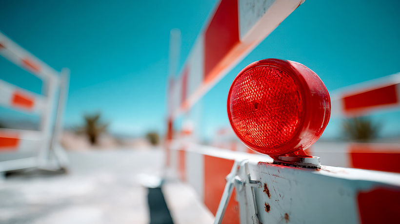 Red road warning light placed between safety barriers on an urban construction site Heruntergeladen Red road warning light placed between safety barriers on an urban construction site 