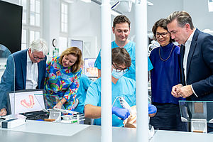 Ein Student demonstriert die Arbeit mit dem Intraoralscanner (v. l. n. r.: Wolfgang Beck, Prof. Heike Kielstein, Prof. Jeremias Hey, Julian Lothar Runkel, Prof. Kerstin Bitter und Thomas Wünsch).