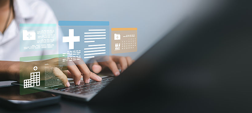 Close up of hands typing on laptop with digital healthcare interface displaying patient records, medical data analysis, and hospital building icons for modern health technology concept.