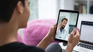Patientin spricht via Tablet mit einem Arzt